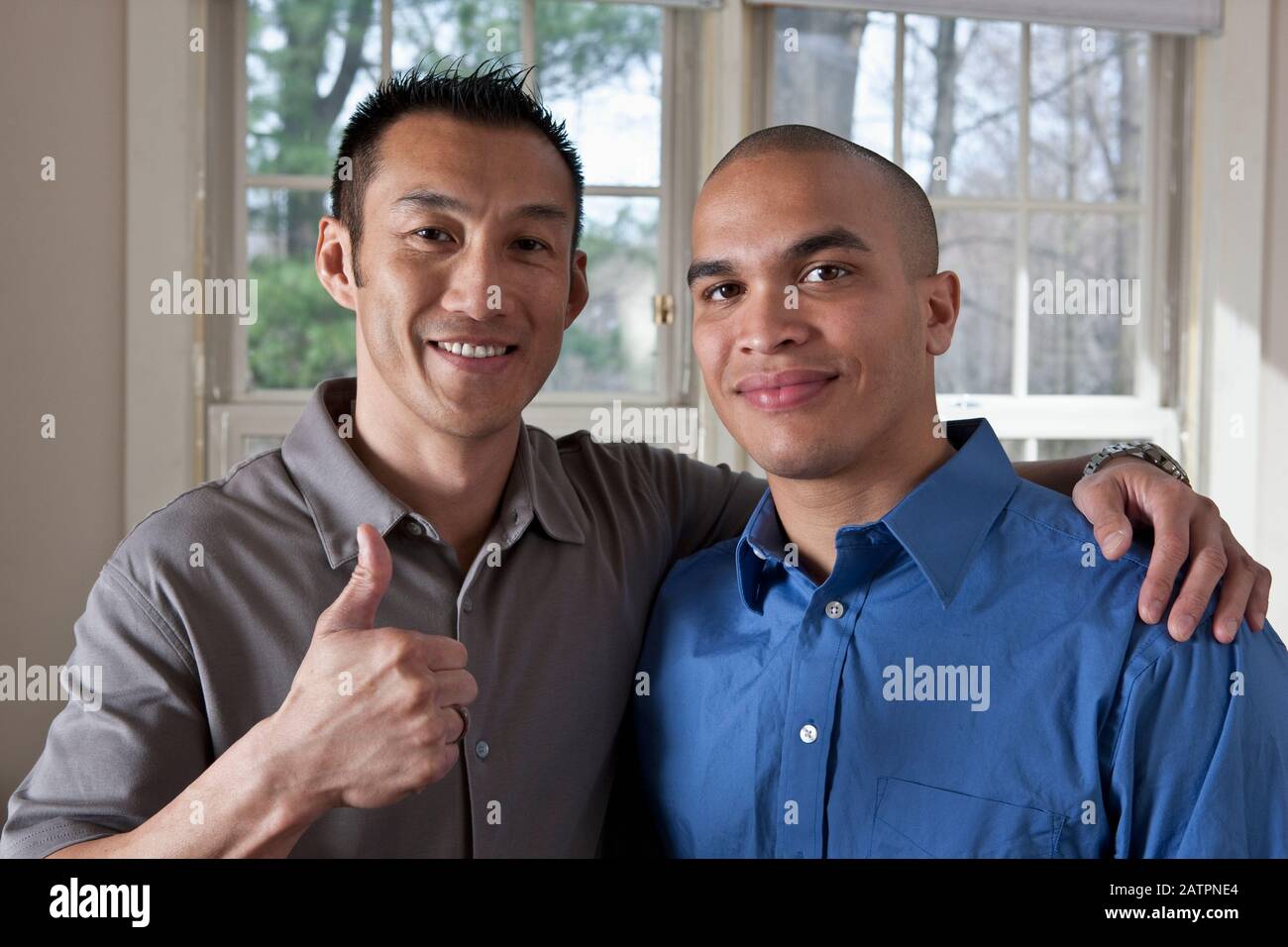 Portrait of two young businessmen standing side by side in an embrace ...