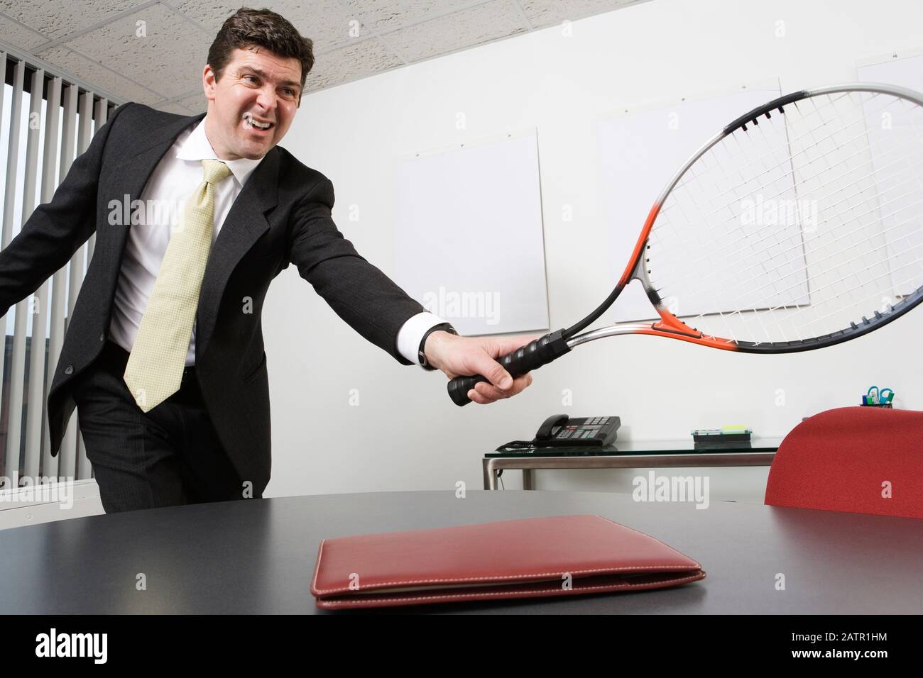 View of a business man holding a tennis racquet in an office Stock Photo -  Alamy