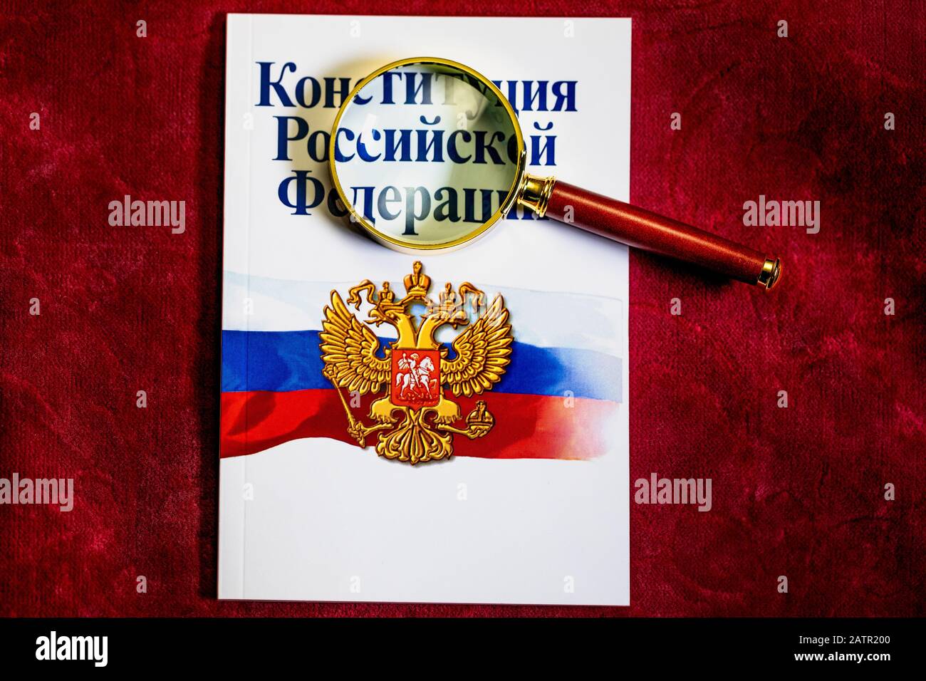 The Constitution of the Russian Federation' under a magnifying glass on red background Stock Photo
