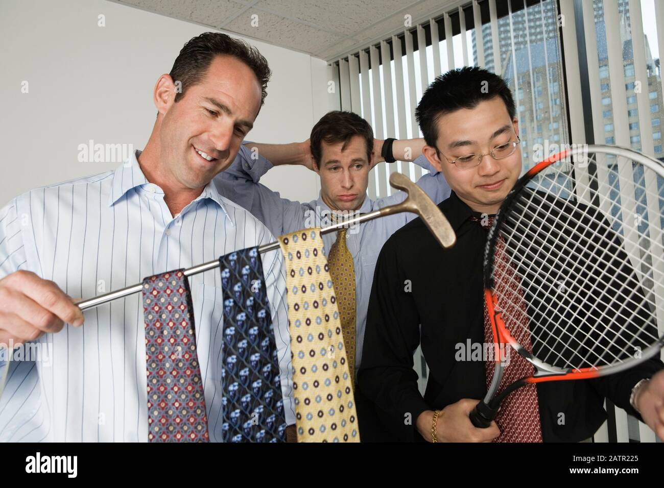 View of businessmen holding a golf club and a tennis racket Stock Photo ...
