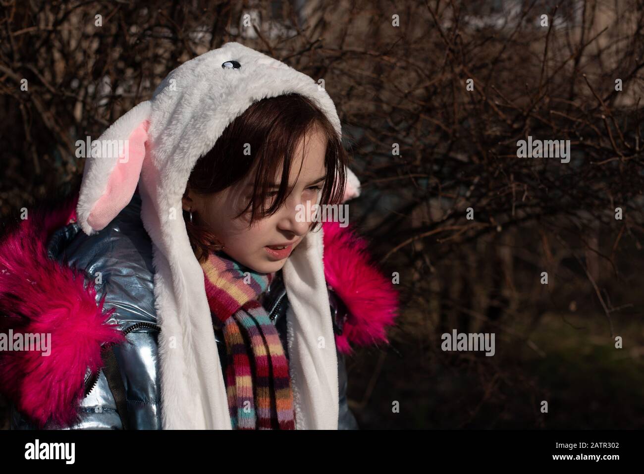 cute little girl in hood with ears. girl in a hat bunny street. Beautiful  young cute