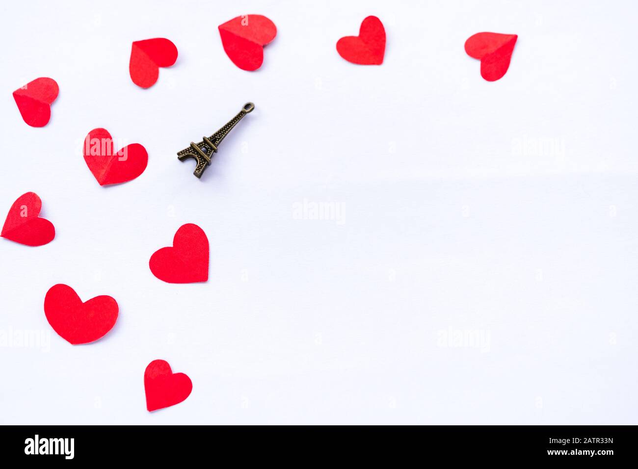 Little red hearts with miniature eiffel tower isolated on white background with copy space. Background for valentines day template, poster, greetings Stock Photo