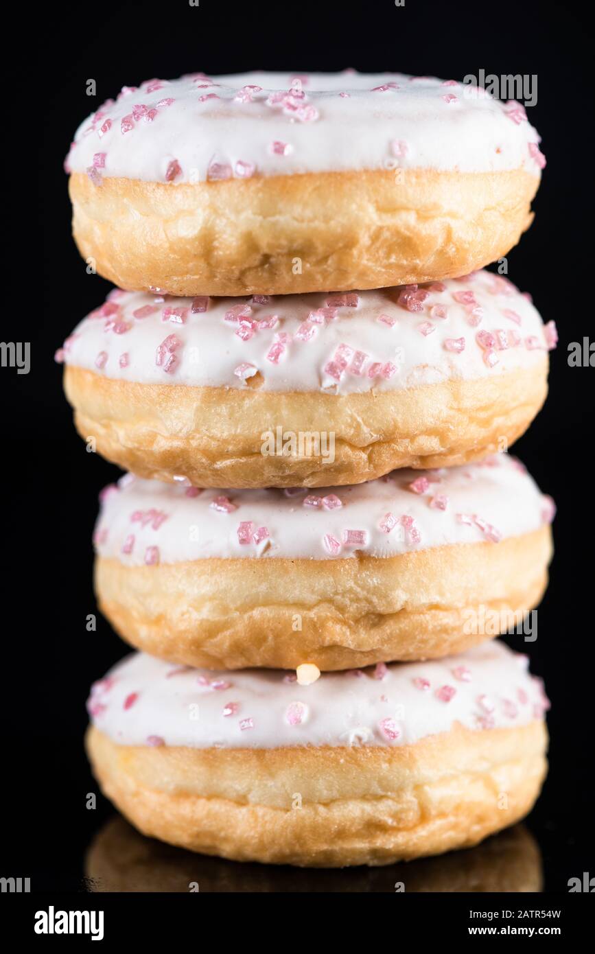 White Chocolate Donuts or Doughnuts Tower on Dark Background . Stock Photo