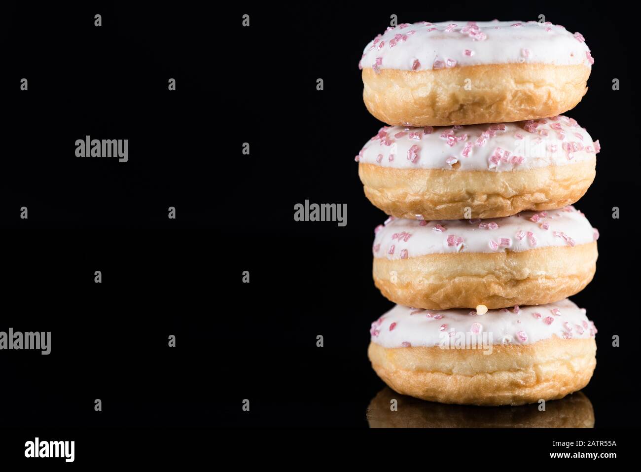 White Chocolate Donuts or Doughnuts Tower on Dark Background . Stock Photo