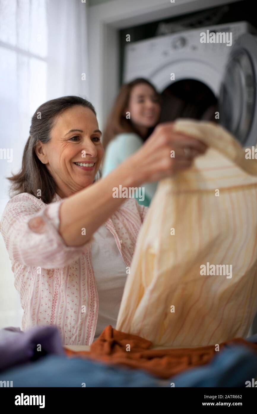 Smiling mature woman folding clean laundry Stock Photo Alamy