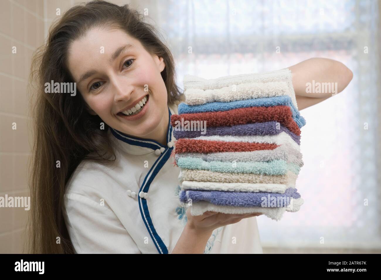 https://c8.alamy.com/comp/2ATR67K/portrait-of-a-mid-adult-woman-holding-a-stack-of-washcloths-and-smiling-2ATR67K.jpg