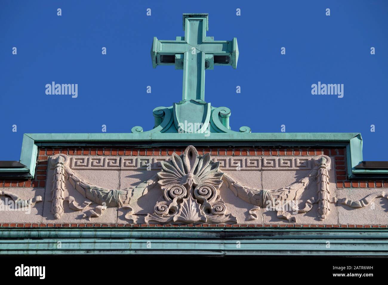 Roof top with oxidized green copper decorative cross and ornament, front view, facade building, Rosemont, Montreal, Quebec, Canada Stock Photo