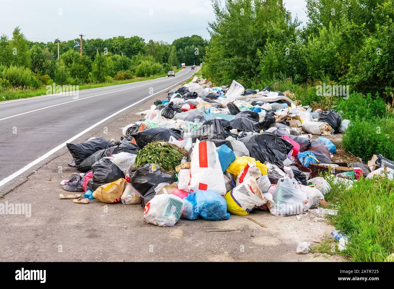 a pile of garbage bags and other debris on the side of the road