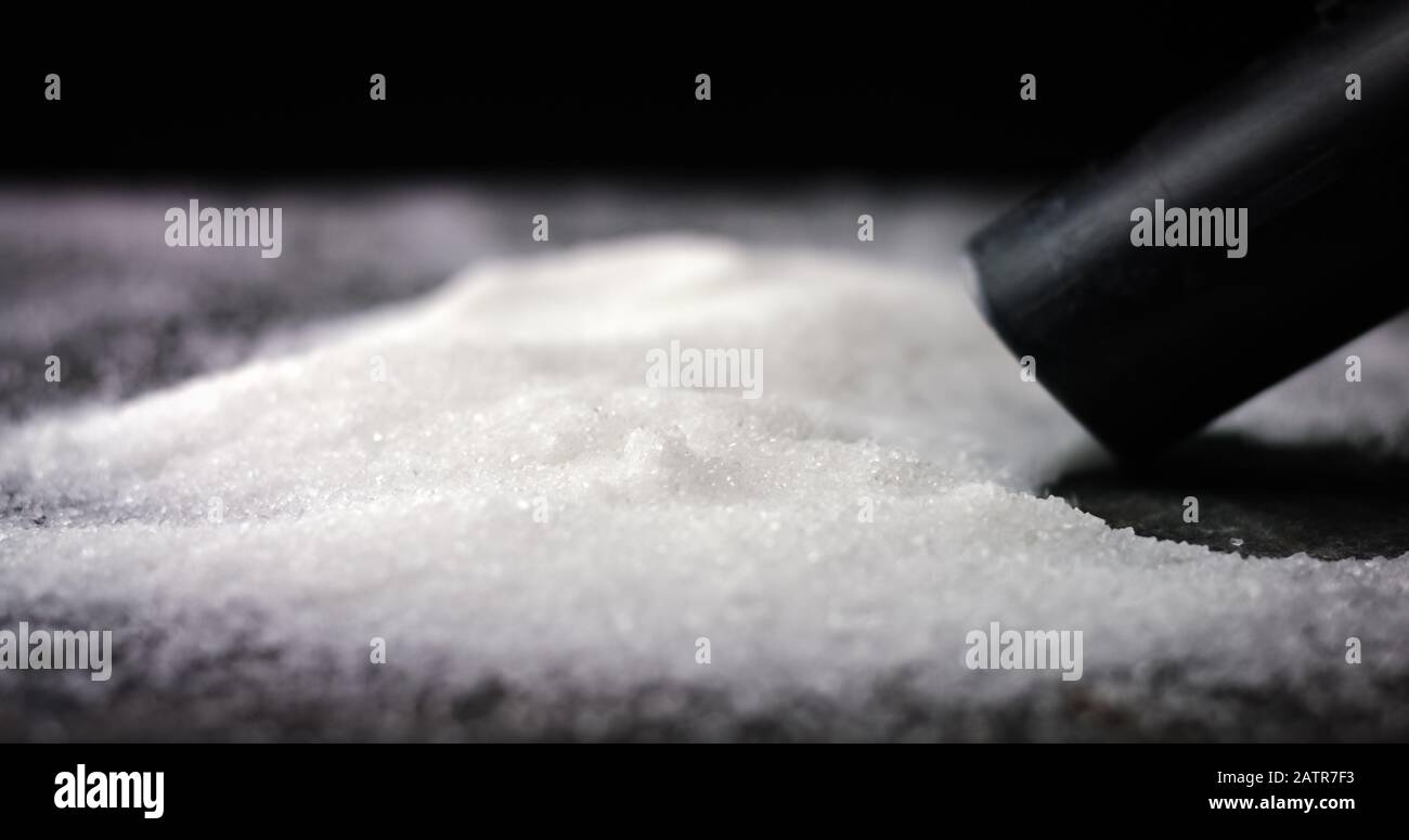 Sucking sugar or salt of a table. Deadly and toxic food. Obesity and diabetes epidemic Stock Photo