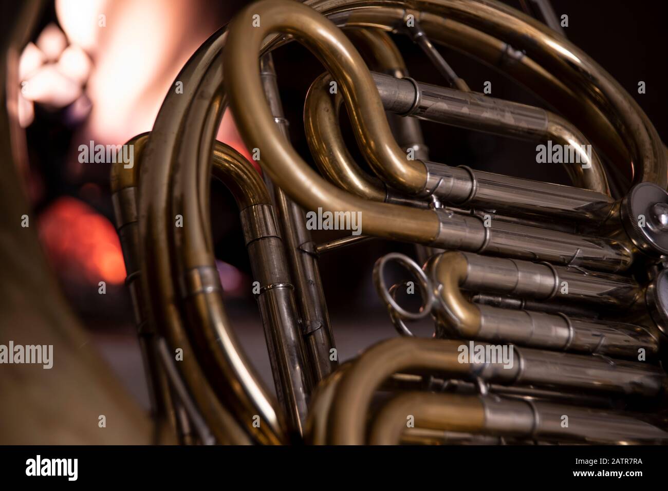 Closeup detail of a brass French horn with the coiled tubing and valve ...
