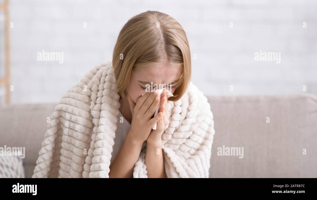 Close up of sick girl blowing her nose Stock Photo