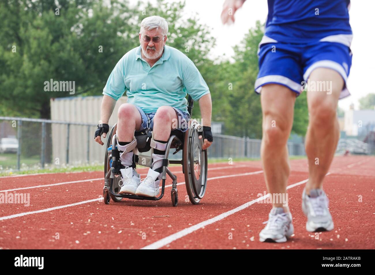View of a handicapped senior man racing with a young man Stock Photo ...