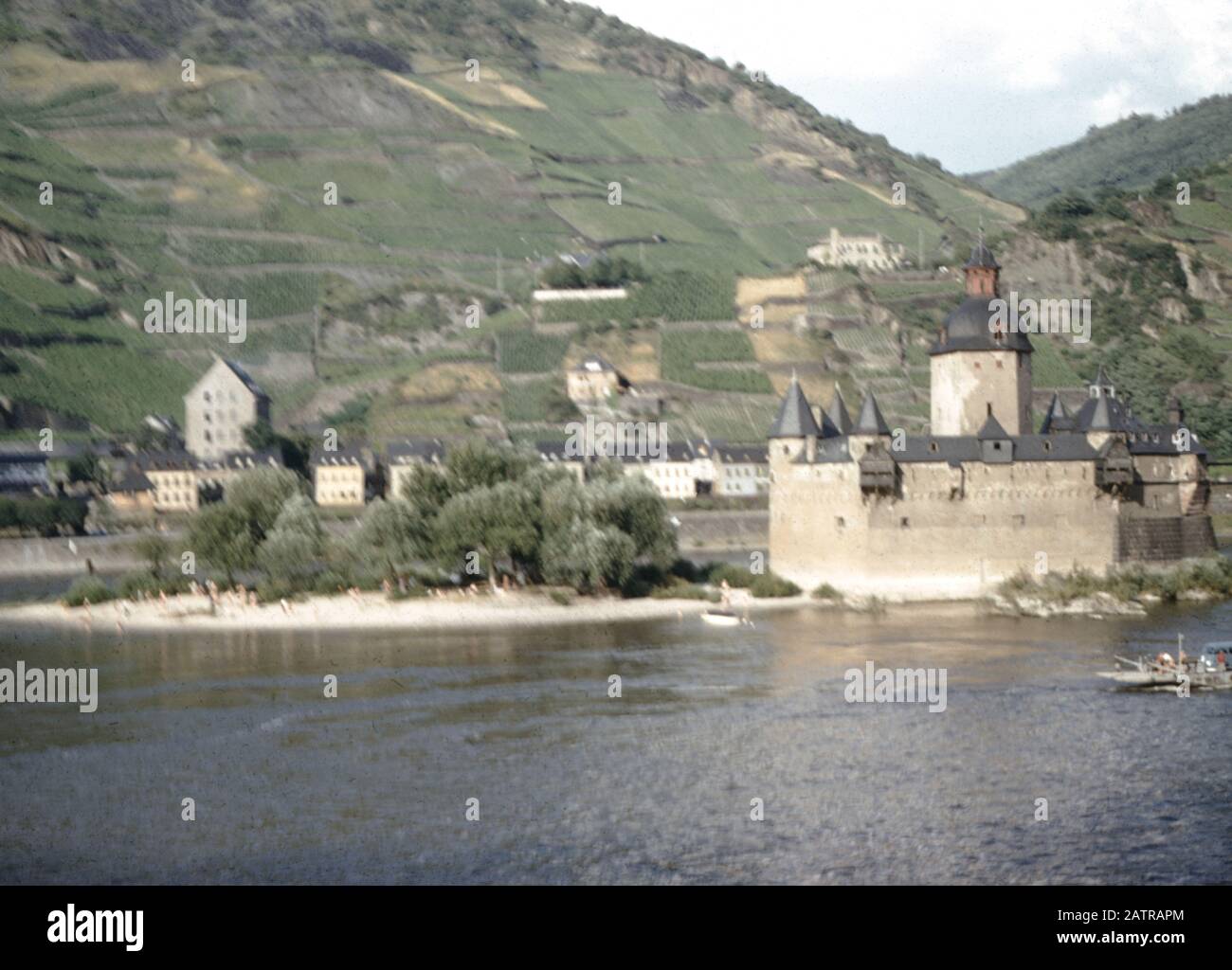 Vernacular photograph taken on a 35mm analog film transparency, believed to depict white concrete building near body of water during daytime, 1965. Major topics/objects detected include Water, River, Fortress, Castle, Fortification, Building and Gray Color. () Stock Photo
