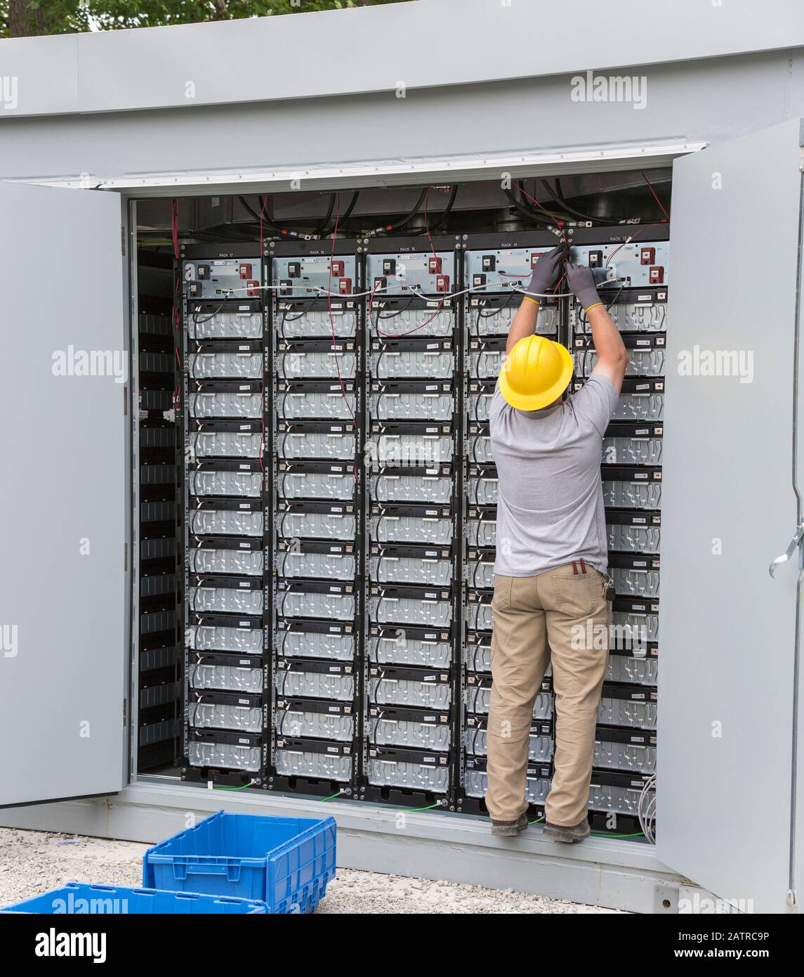 Engineer connecting energy storage batteries for back up power to an electric power plant Stock Photo