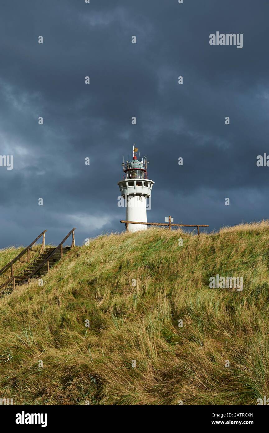 Leuchtturm in Egmondaan Zee vor dramatisch bewoelktem Himmel Stock Photo