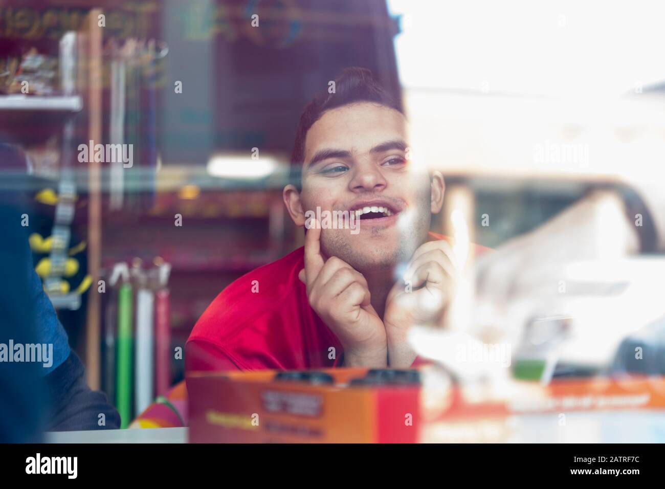 Middle Eastern man with Down Syndrome smiling at work Stock Photo