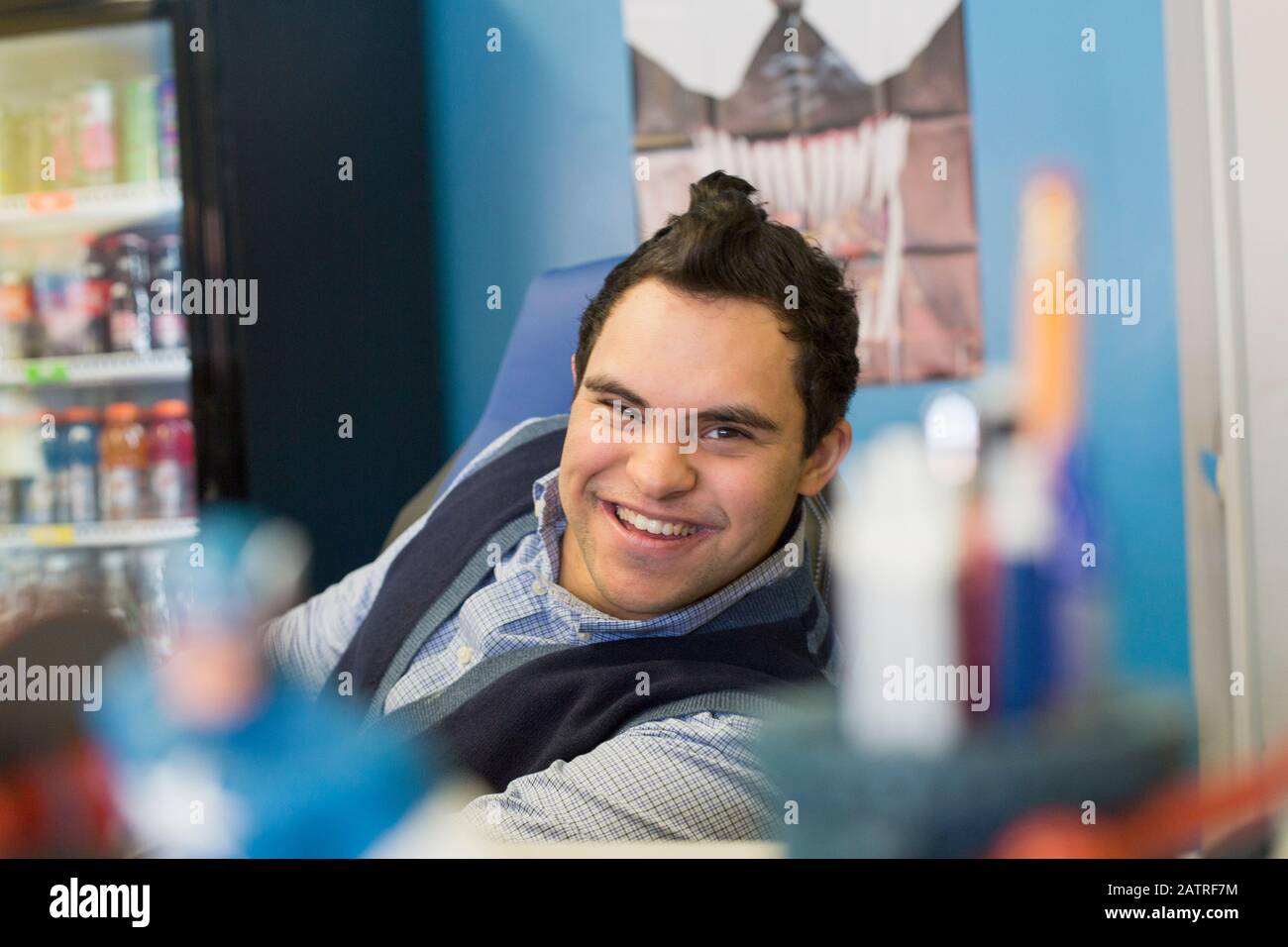 Middle Eastern man with Down Syndrome smiling at work Stock Photo