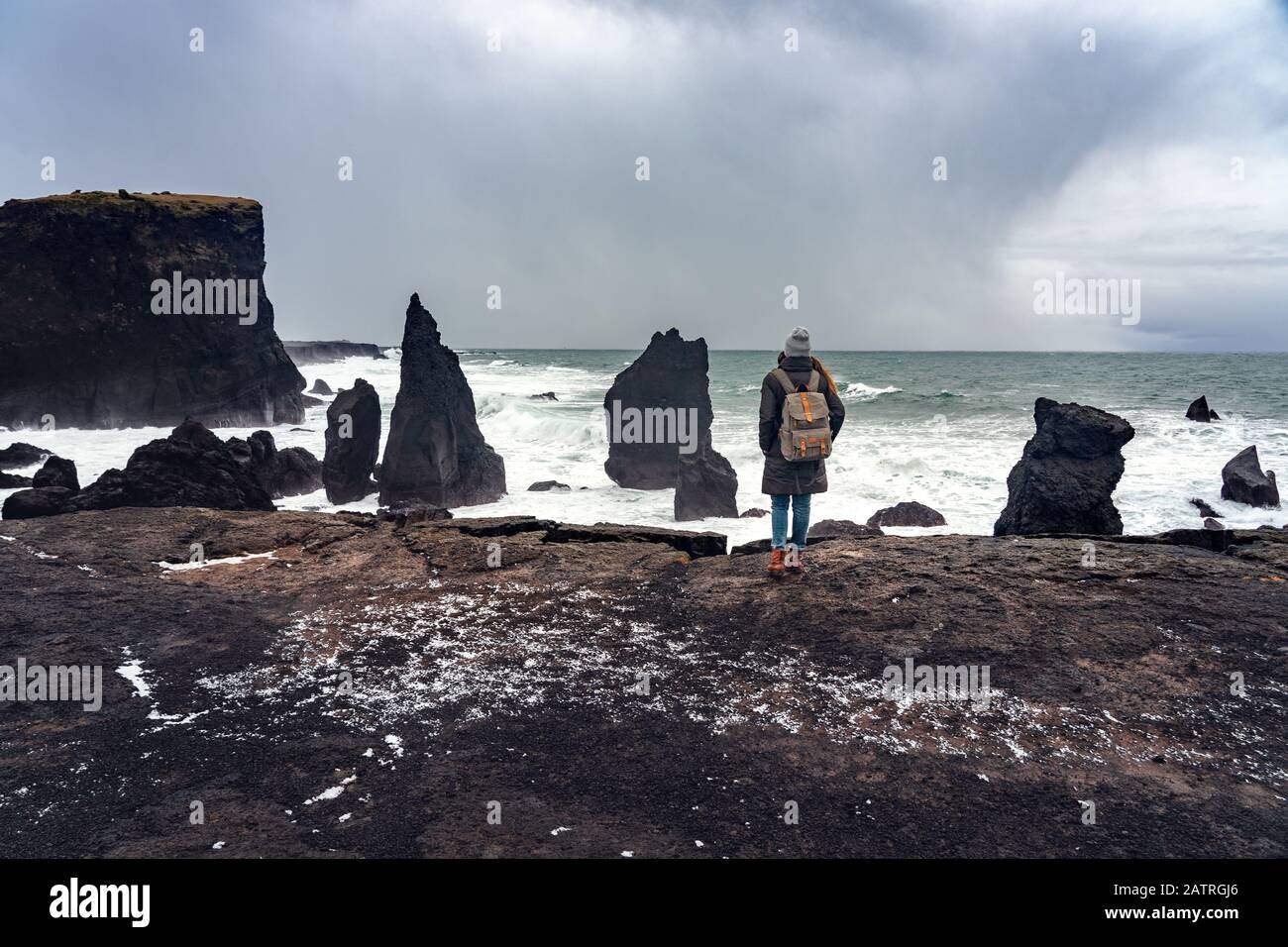 woman standing on the cliff and watching the power of the ocean on the reykjanesviti seacoast in Iceland Stock Photo