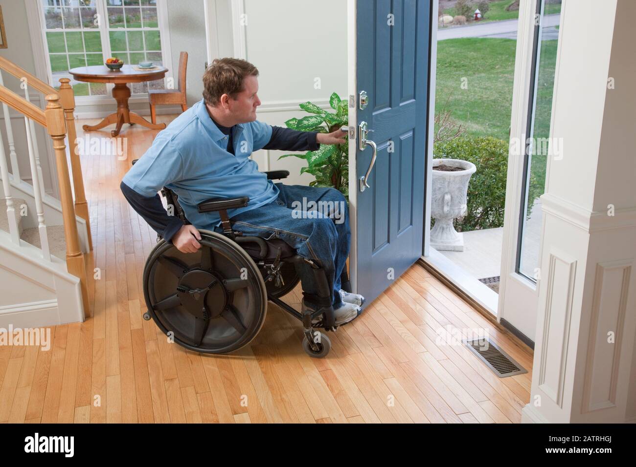 Man in a wheelchair opens the front door of his home and looks out Stock  Photo - Alamy, image size:1300x956