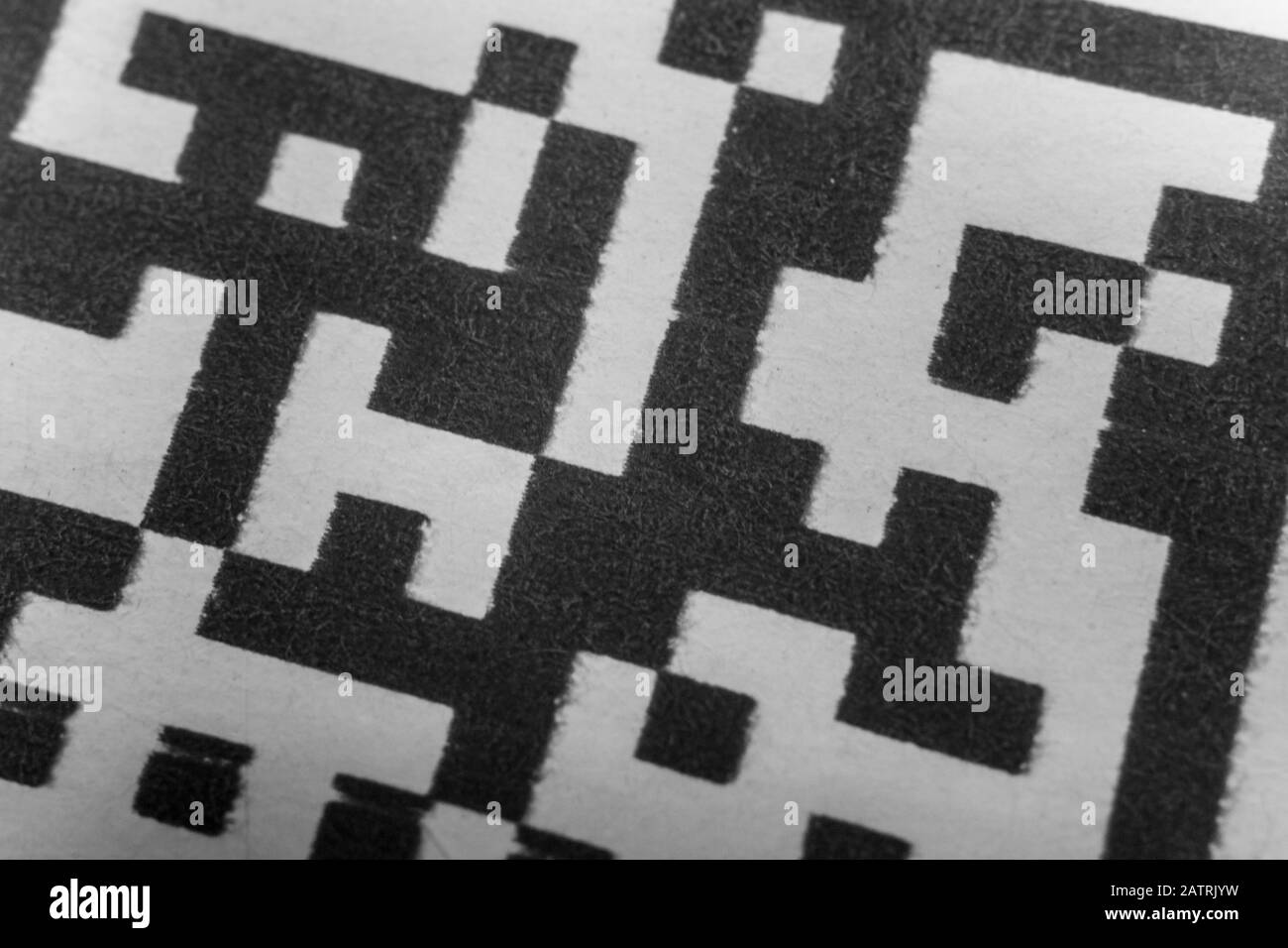 Abstract monochrome close up of isolated printed QR data matrix bar code on white paper label background from material inventory tracking system Stock Photo