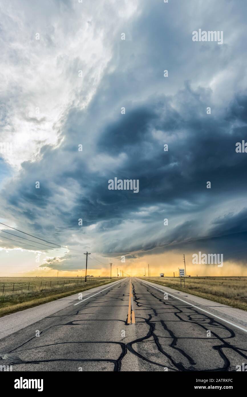 A low precipitation supercell crosses an empty highway near Roswell, New Mexico; Rowell, New Mexico, United States of America Stock Photo