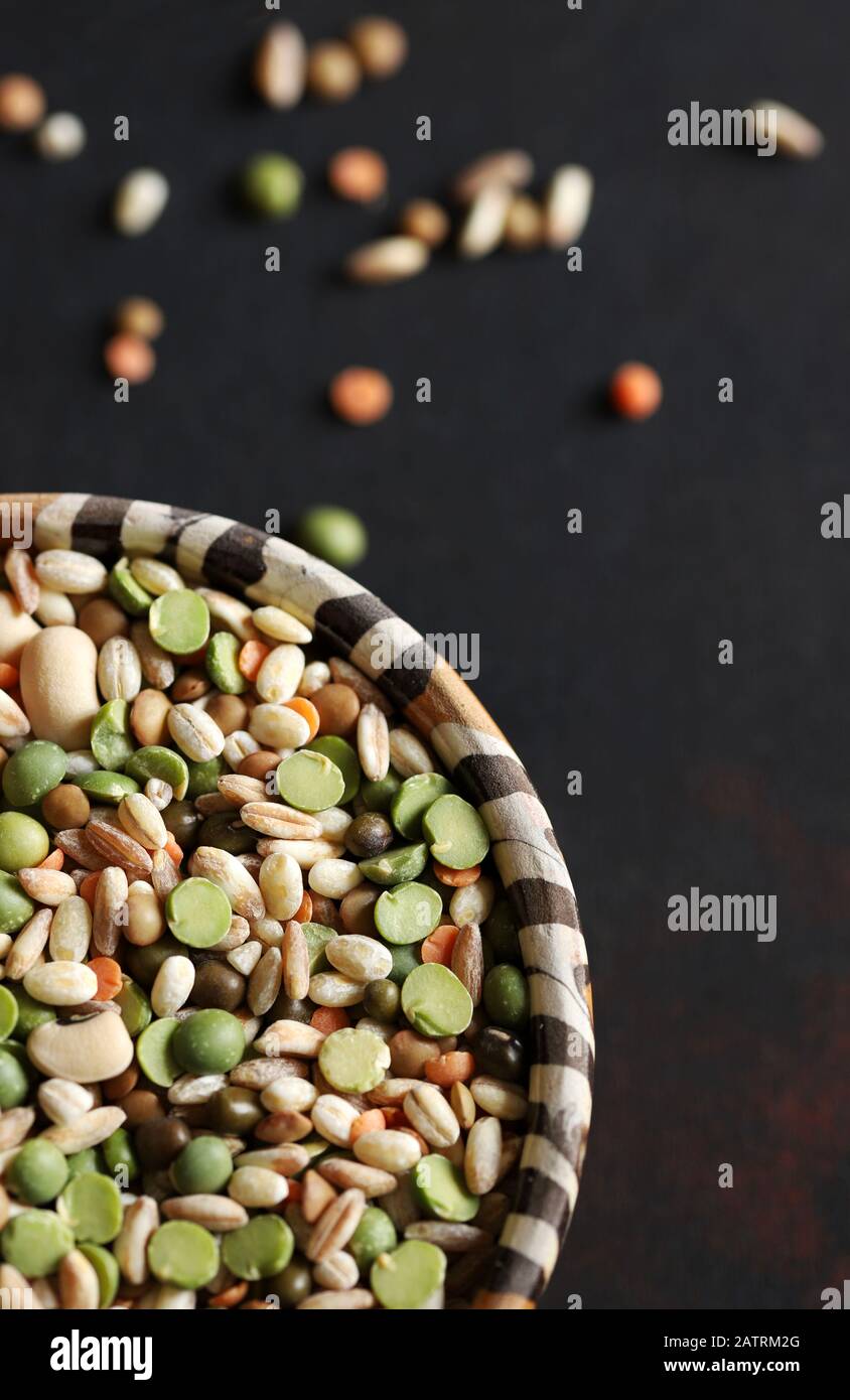 Mixed dried legumes in the bowl isolated on dark background.Top view. Stock Photo
