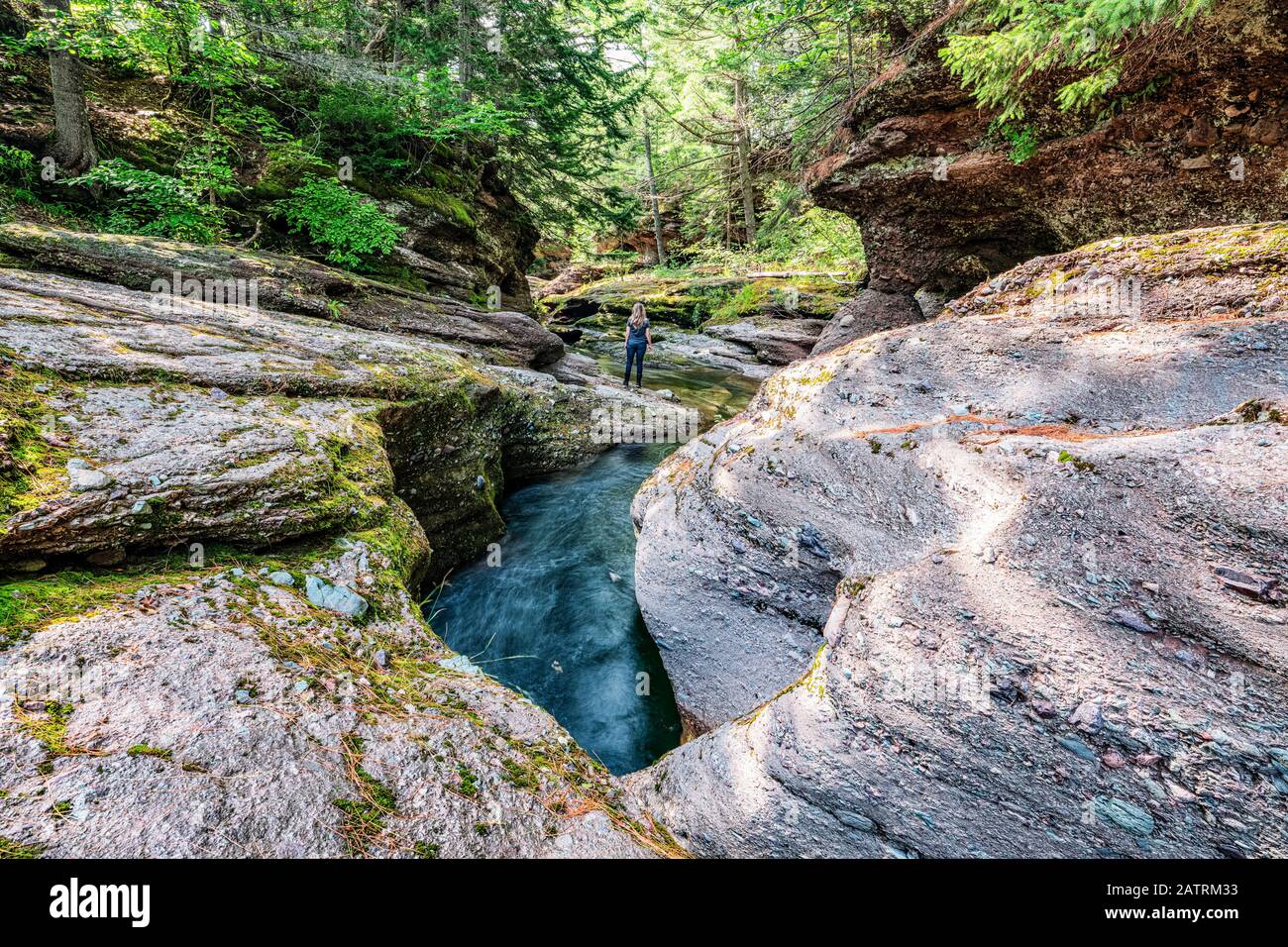 Woman standing in a hidden canyon along the backroads of New Brunswick; Saint John, New Brunswick, Canada Stock Photo