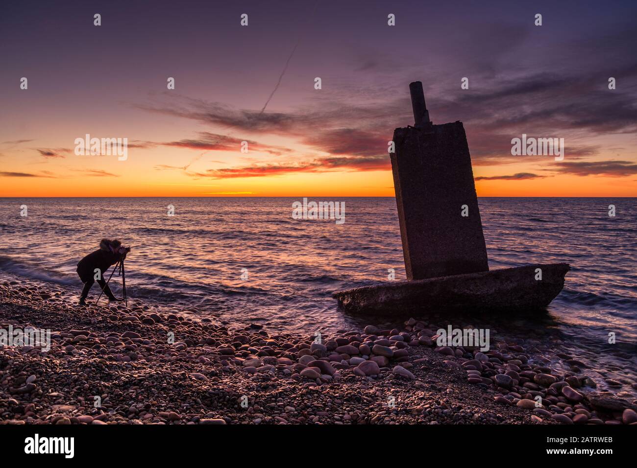 Photographer woman in the sea in a beautiful sunrise Stock Photo - Alamy