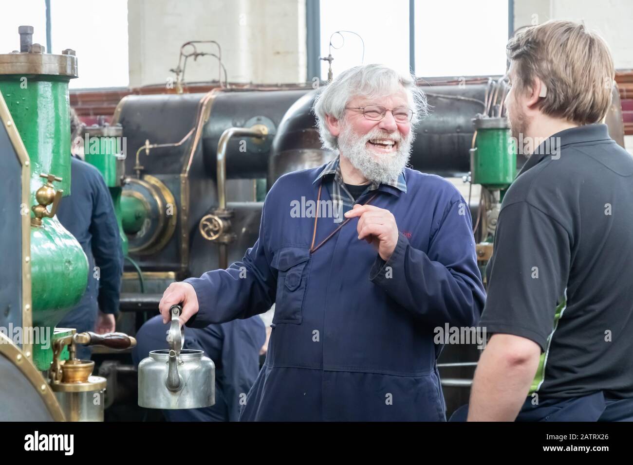 Two volunteers chat during one of the regular, monthly steamings at Ellenroad Museum, home of the world's largest working steam mill engine Stock Photo