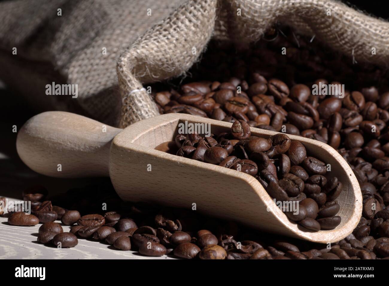 Coffee beans in a scoop with hessian bag on wood Stock Photo