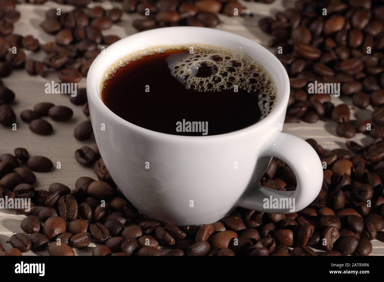 A cup of coffee with beans on wood Stock Photo