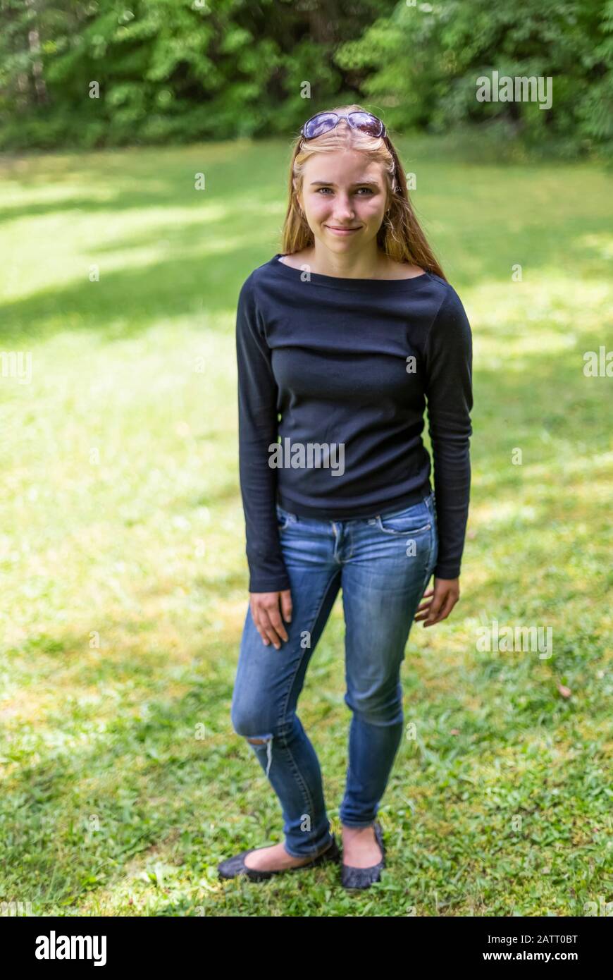 Portrait of a pre-teen girl standing on grass in a  park; Salmon Arm, British Columbia, Canada Stock Photo
