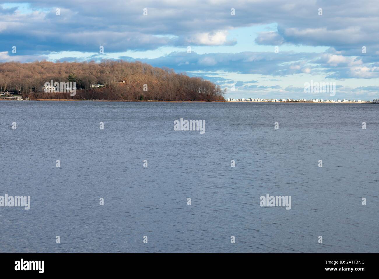 Late afternoon clouds fill the blue sky over the Navesink River at