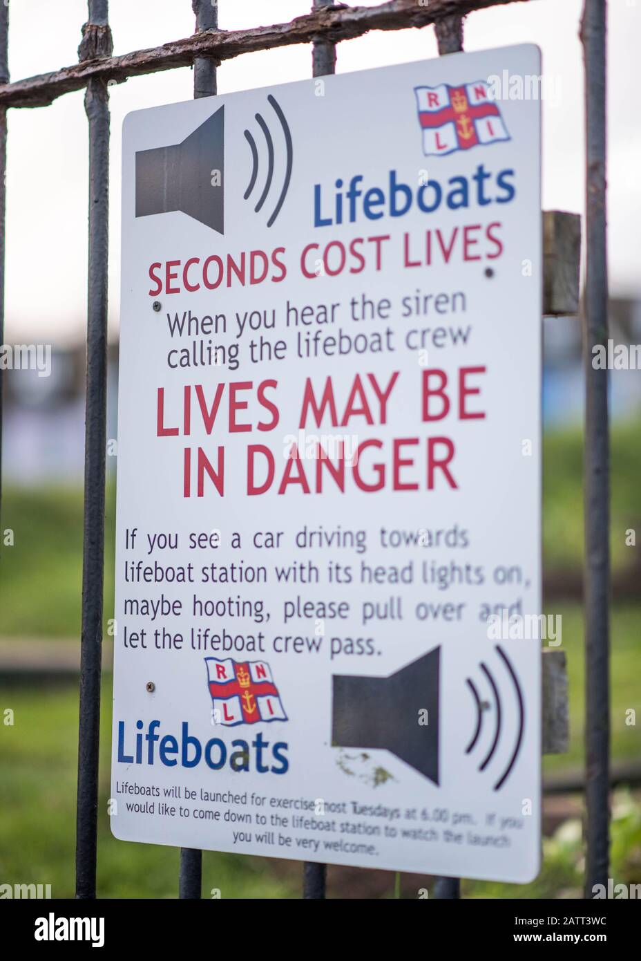 RNLI Lifeboat siren alert sign mounted on metal railings in the coastal village of Appledore in North Devon, England Stock Photo