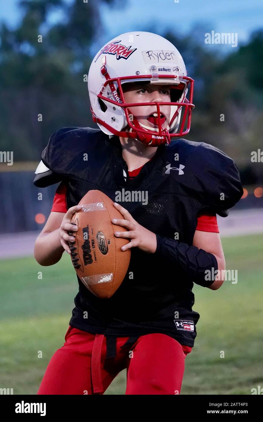 A youth quarterback in action while playing football Stock Photo Alamy