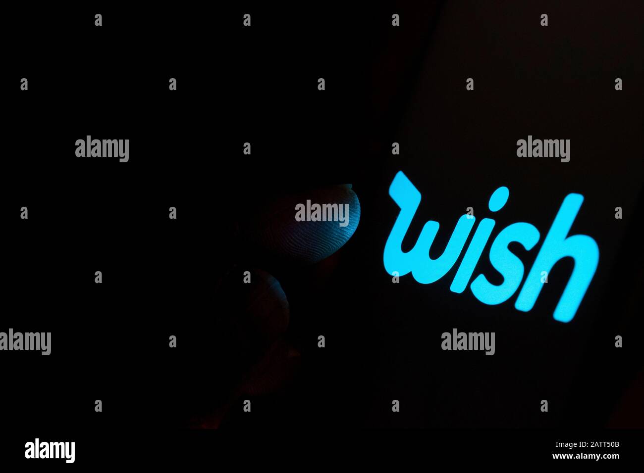 Wish trading platform logo on the screen and finger pointing at it. Concept photo. Stock Photo