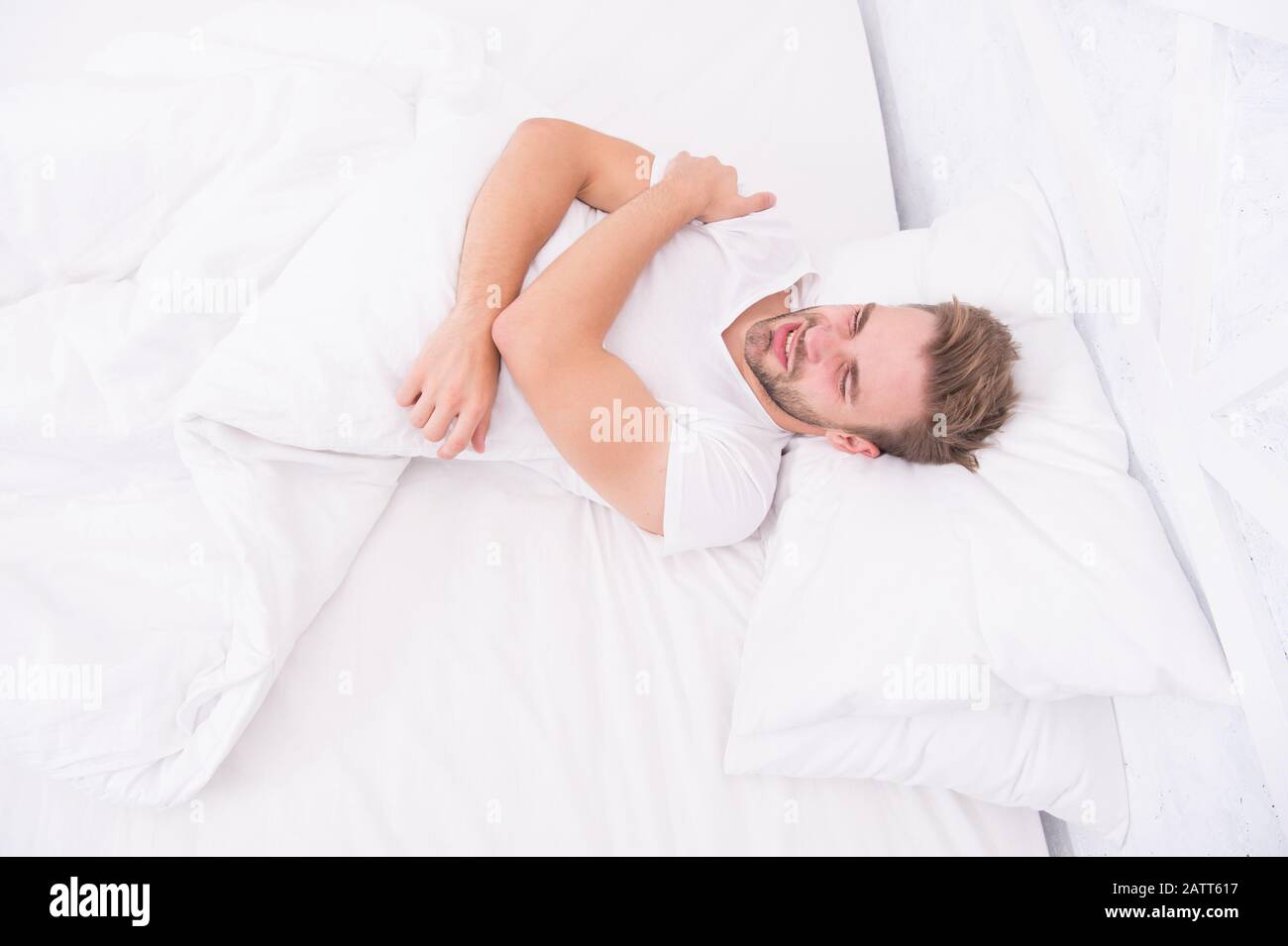 Sleep problems can lead to headaches in morning. Migraine headaches. Handsome man relaxing in