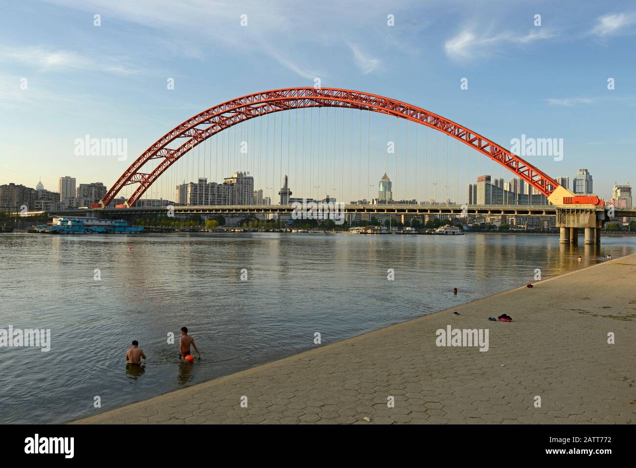 Swimmers exercise below the Jingchuan Bridge over the Han river, Wuhan, China Stock Photo