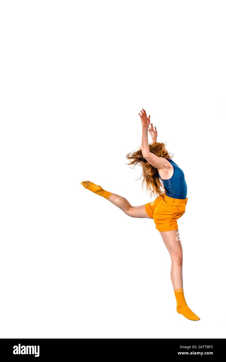 Female dancer jumping in the air wearing fashionable clothes Stock