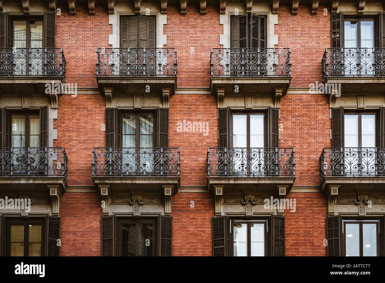 Red brick facade with wrought iron balconies Stock Photo
