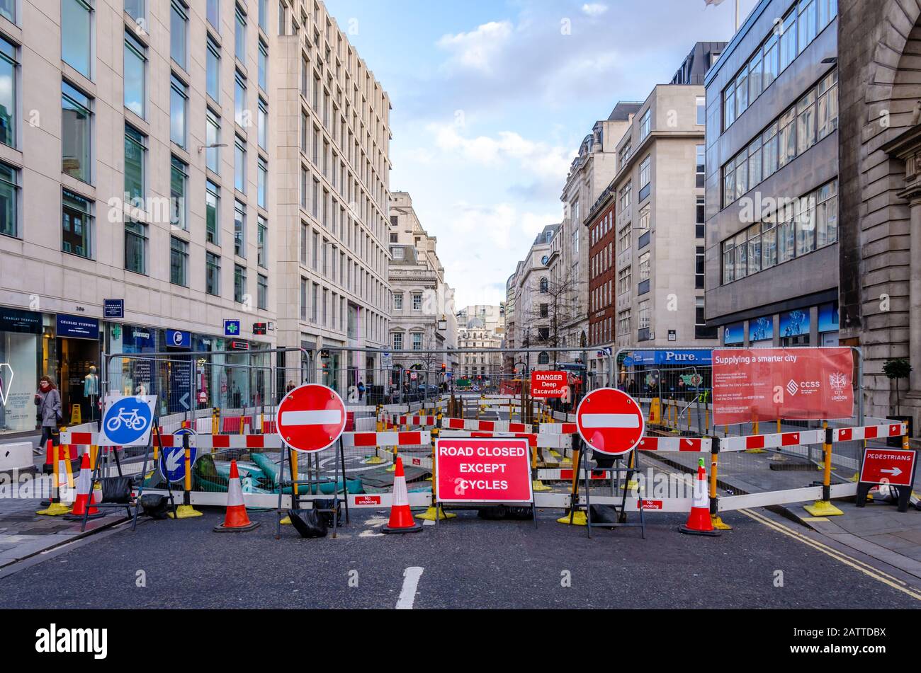 A London street is closed because of engineering works, Lots of red signs and barriers surround the roadworks. Stock Photo