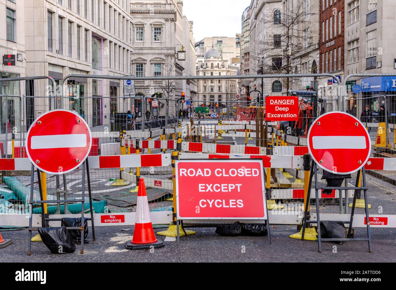 A London street is closed because of engineering works, Lots of red signs and barriers surround the roadworks. Stock Photo