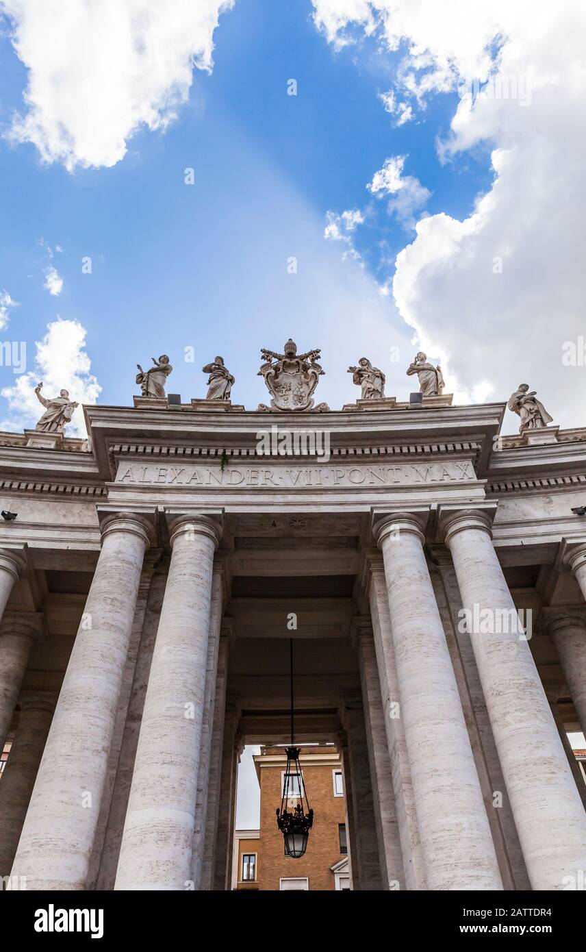 The southern entrance to St. Peter's Square through the colonnade, marked by a coat of arms of Alexander VII, Vatican City, Rome, Italy. Stock Photo