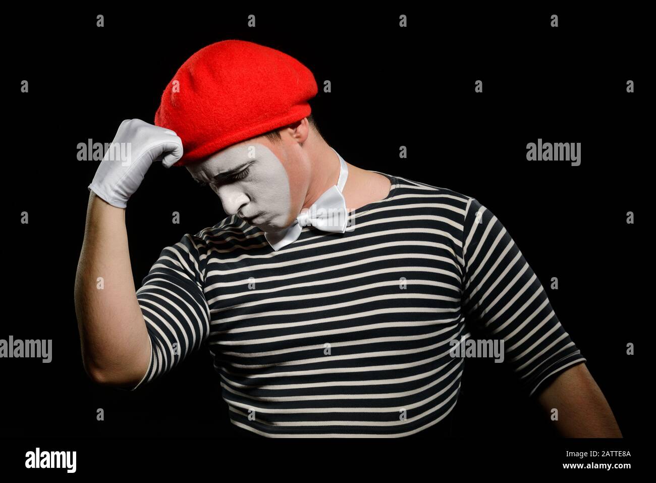 Thoughtful mime, isolated on black. Dressed in black and white striped