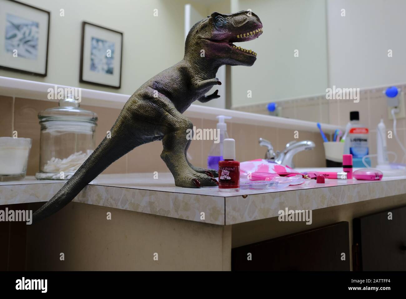 T-Rex covered in makeup on a messy makeup-strewn bathroom counter. At least it wasn't the cat. Ottawa, Ontario, Canada. Stock Photo