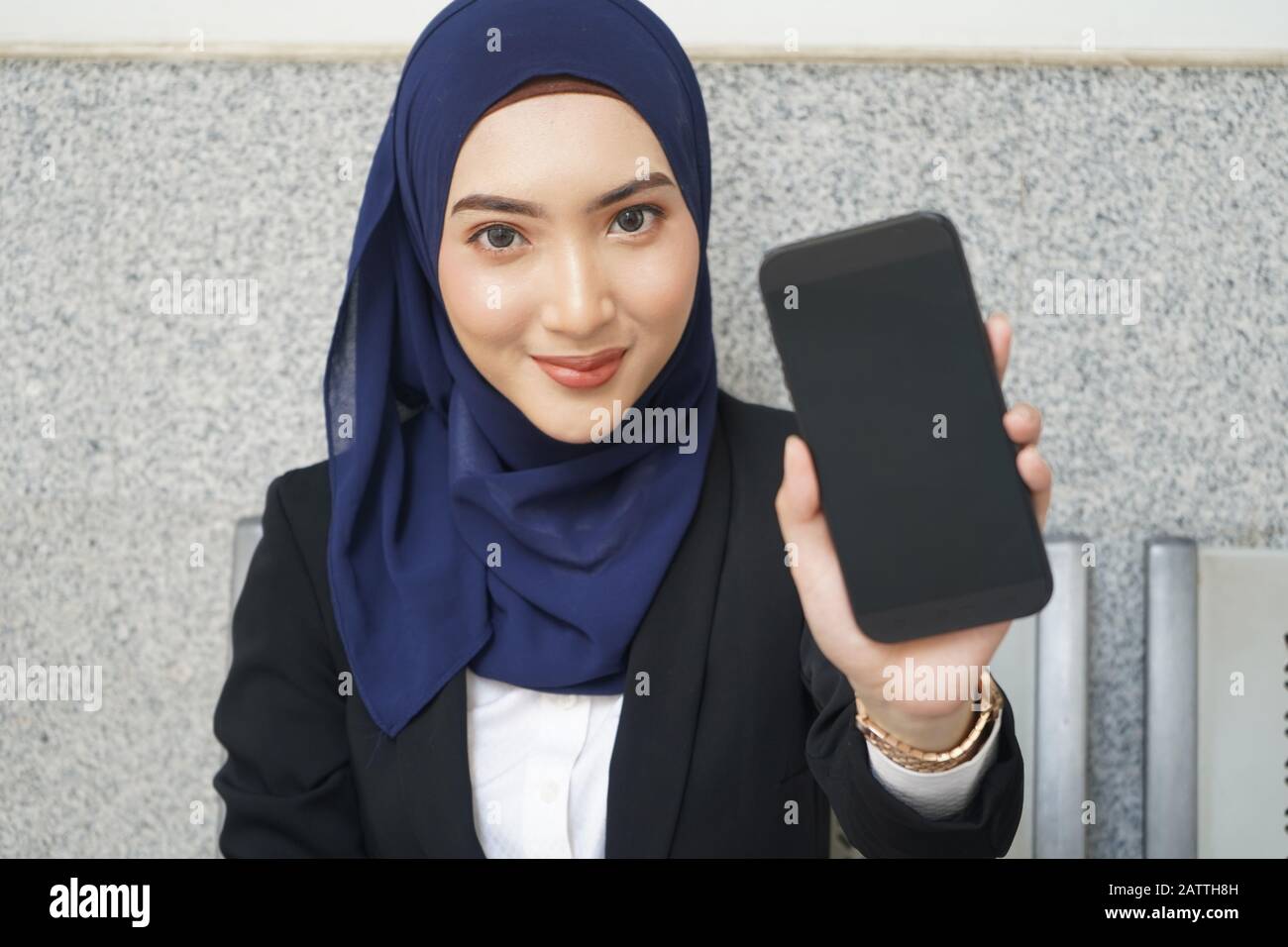 Portrait of young muslim woman 20s in islamic headscarf with  black screen of cell phone Stock Photo