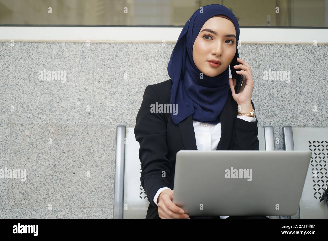 Attractive female muslim woman on a laptop and phone Stock Photo