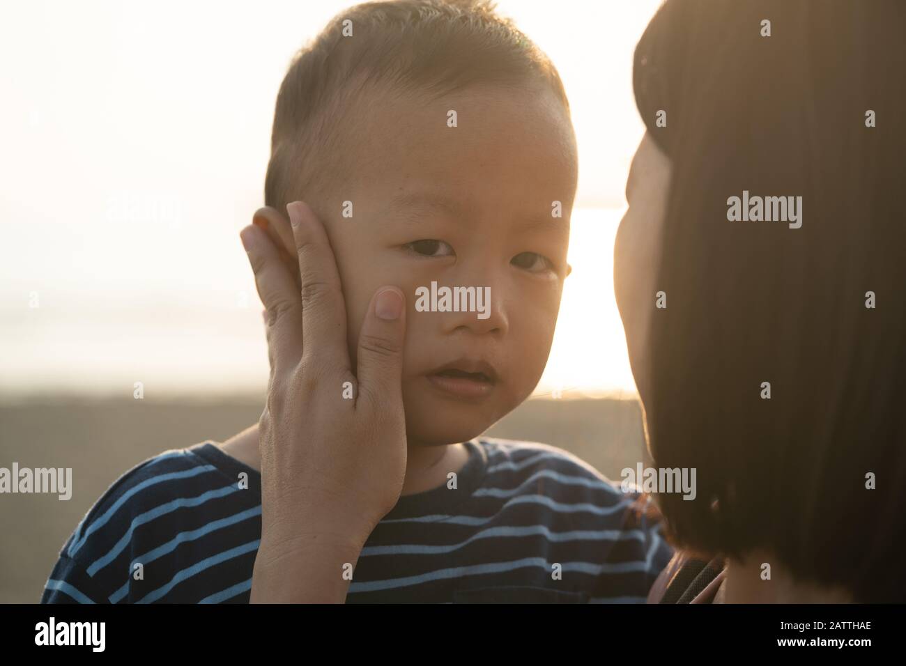asian boy crying with mother comforting Stock Photo