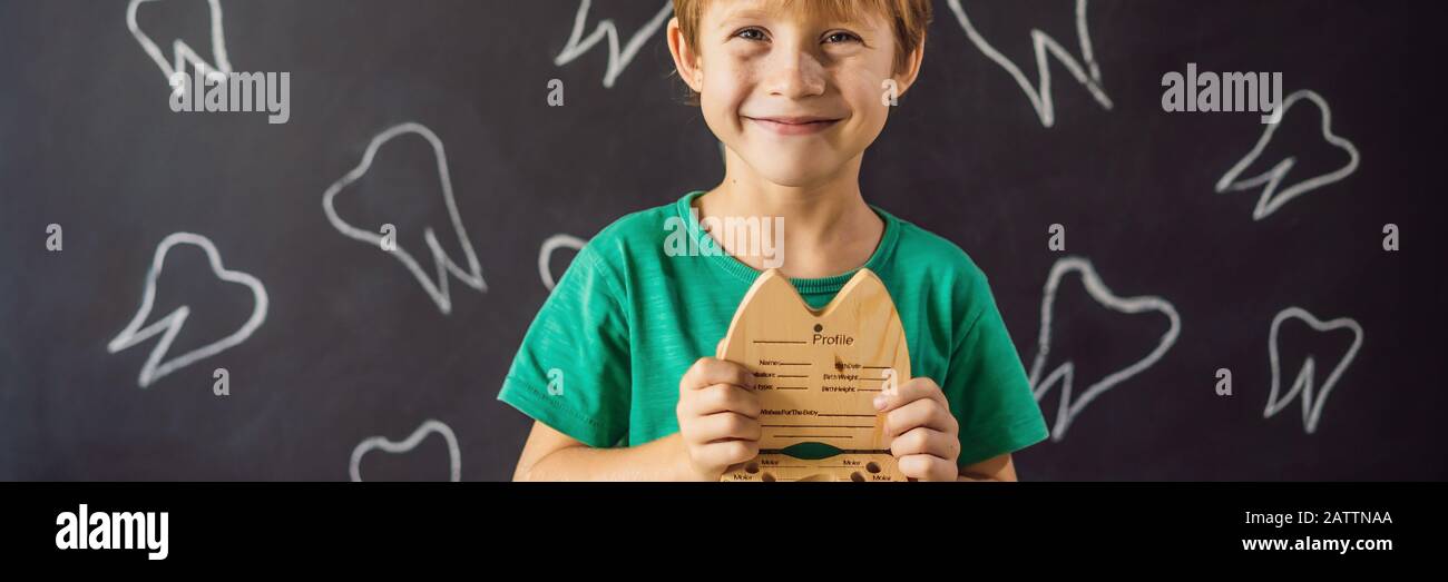 A boy, 6 years old, holds a box for milk teeth. Change of teeth BANNER, LONG FORMAT Stock Photo