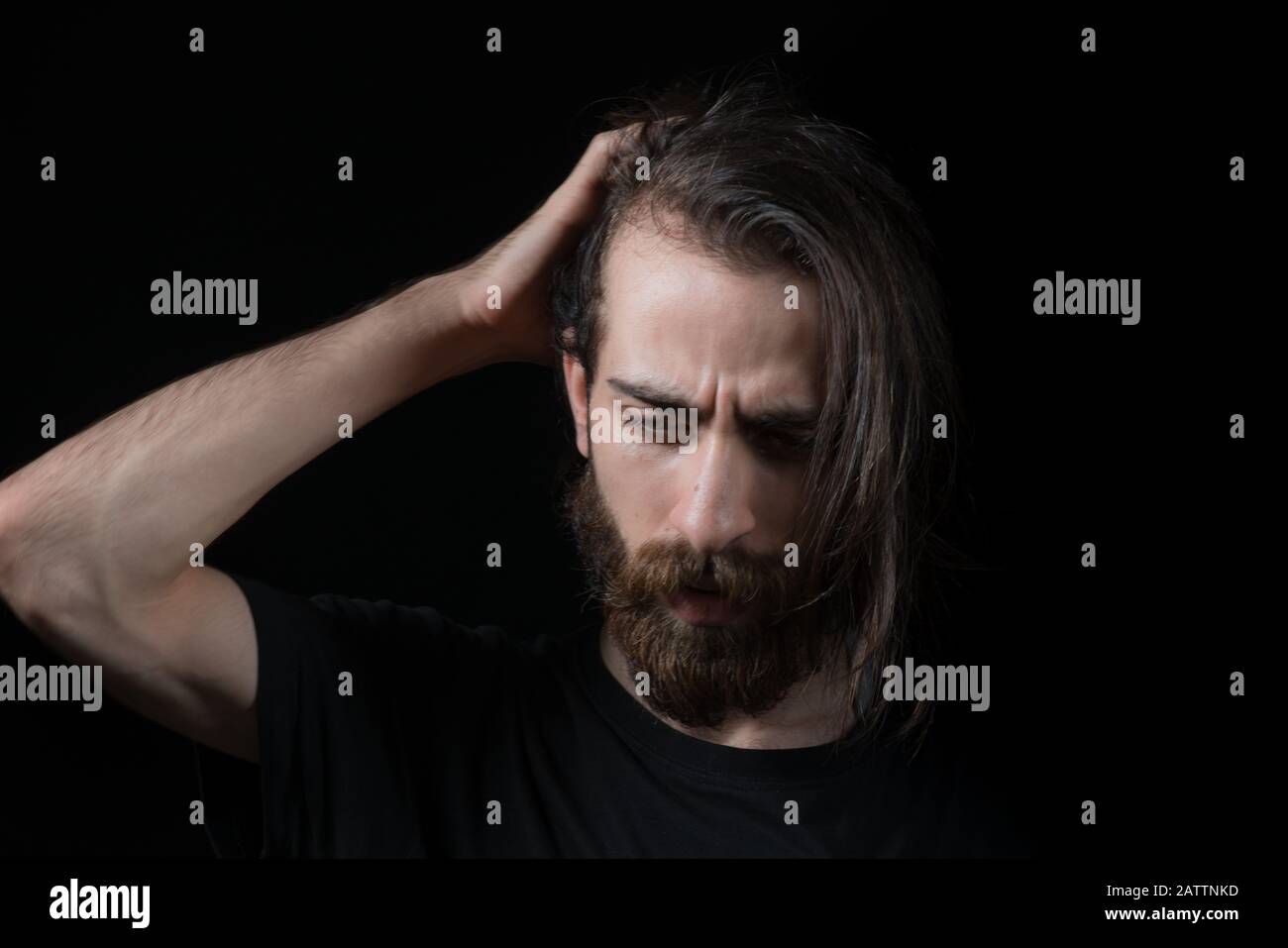 Hipster man solves a problem and thinks. Shot on black isolated background. Thinks Concept. Stock Photo